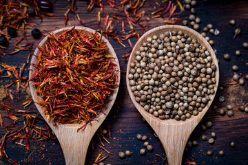 Coloful various spice and herbs in wood spoon on natural texture wood plate.
