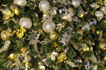 Shiny Christmas and New Year decorations golden and silver colors on a fir tree.