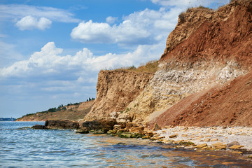 beautiful sea landscape, wild beach at summer, sea coast with high hills and cloudy sky