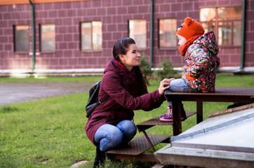 Mom and daughter on the porch in autumn weather