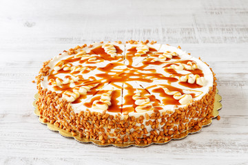 Homemade delicious whole cake with mascarpone cream, white melted chocolate, peanut croquet and...