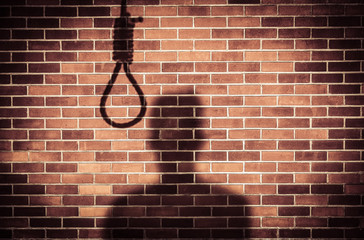 shadow of a sad man with hangman noose on wall while making decision to suicide