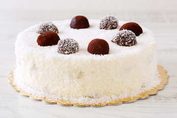 Delicious whole white cake with desiccated coconut powder and cocoa balls icing