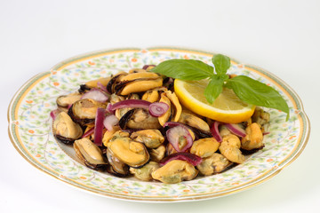 Homemade delicious summer salad with mussels, red onion, olive oil, lemon and basil