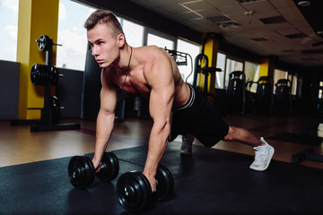 Fototapeta na wymiar Model sports young athletic man exercising in gym.Muscular man during workout in the gym.Portrait of sporty healthy strong muscle.Fitness trainer.Sport workout bodybuilding motivation concept
