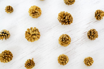 Merry Christmas background - pattern of pine cones gold colour on white background. creative flat lay design.
