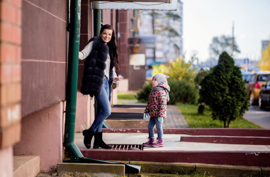 Mom and daughter on the doorstep of the house