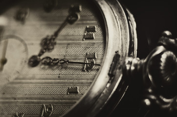 antique pocket watch with vintage golden arrows on the old yellowed dial and clockwork key on a...