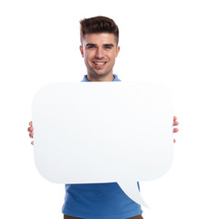 happy young casual man holding a blanck speech bubble