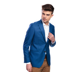 young handsome man looks back and holds collar