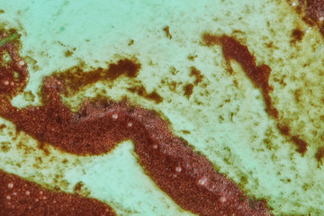 Decorative background from melted ice cream in a green and brown tones.