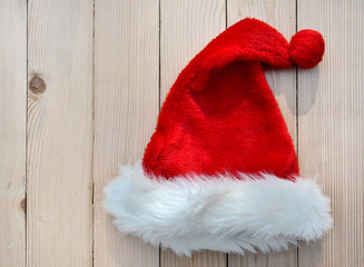 Obraz na płótnie Canvas santa hat in fur on a wooden background