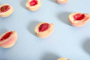 Ripe beautiful peaches with bones divided in half stacked in a row