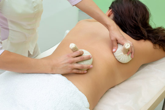 Woman having spa bags massage in wellness salon