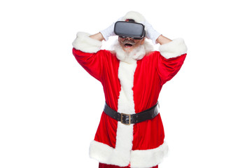 Christmas. Santa Claus in black virtual reality glasses makes gestures with his hands. Surprise, emotion. New technology. Isolated on white background.