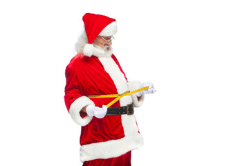 Christmas. Santa Claus is measuring waist with a tape. The concept of weight loss, healthy eating....