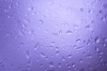 blur drops of rain on blue glass background