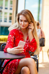 Beautiful young woman taking pictures of herself on a cellphone