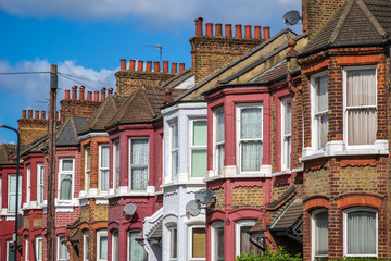 A row of typical British terraced houses in London with a telephone pole