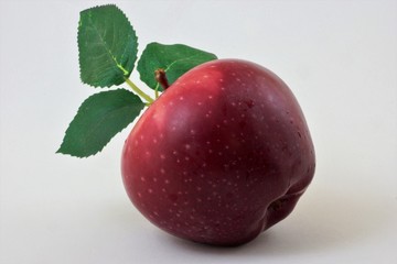 Beautiful ripe red Apple with green leaves consumed fresh, used in cooking.