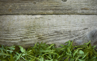 Fresh rucola leaves, on wooden background