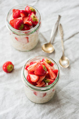 Overnight oats or oatmeal in jar topped with strawberries. Healthy eating, healthy lifestyle, dieting and modern trendy lifestyle concept