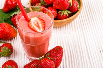 fresh strawberrysmoothie or milkshake on a wooden rustic background