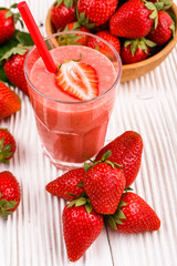 fresh strawberrysmoothie or milkshake on a wooden rustic background