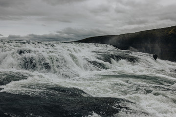 beautiful mountain river flowing under cloudy sky in Iceland