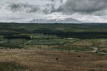  landscape with mountains covered by snow under cloudy sky in Iceland