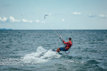 Kitesurfing Kiteboarding action photos man among waves quickly goes