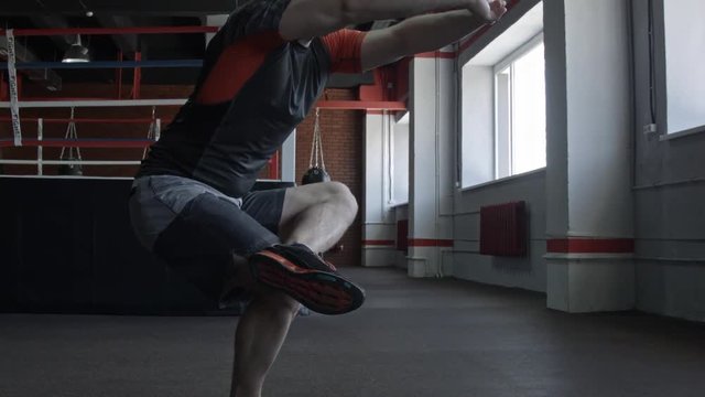 Young man preparing muscles before training. Muscular athlete exercising in gym. Fit man stretching. Professional sportsman warming-up. Full body length portrait