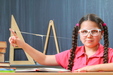 Happy school girl in front of the blackboard