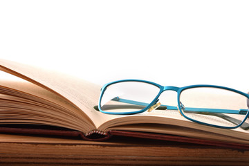 Reading glasses on wood table with open book front