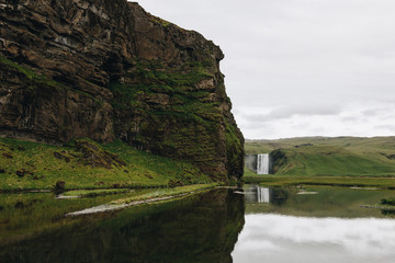 Fototapeta na wymiar scenic view of beautiful waterfall Skogafoss in highlands under cloudy sky in Iceland