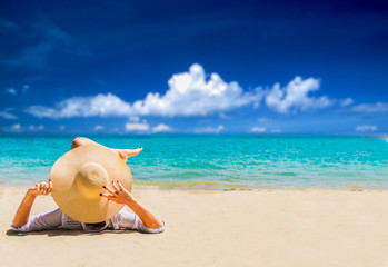 woman relax on the beach. Happy island lifestyle. White sand, blue cloudy sky and crystal sea of tropical beach. Vacation at Paradise. Ocean beach relax