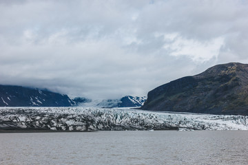 scenic view of glacier Skaftafellsjkull and snowy mountains against cloudy sky in Skaftafell National Park in Iceland