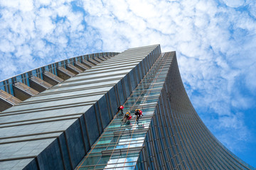 Group of Alpinists in service for windows cleaning of skyscrapers buildings