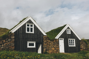 Black farmhouse in Skaftafell National Park under cloudy sky in Iceland