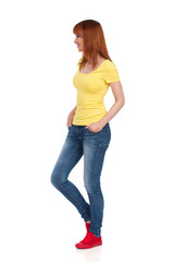 Side View Of Smiling Casual Young Woman Standing And Looking Away