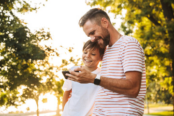 Happy father spending time with his little son at the park