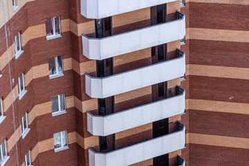 White balconies on the building of red brick