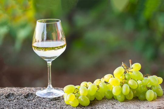 a glass of white wine and white grapes