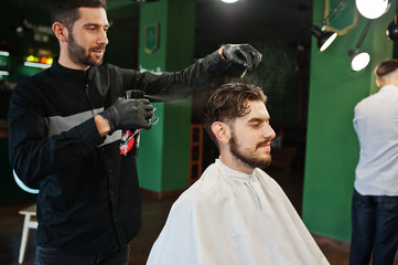 Handsome bearded man at the barbershop, barber at work.