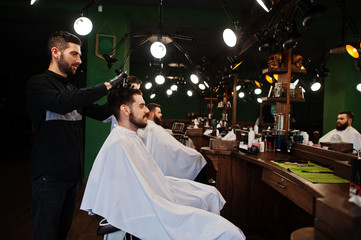 Handsome bearded man at the barbershop, barber at work.