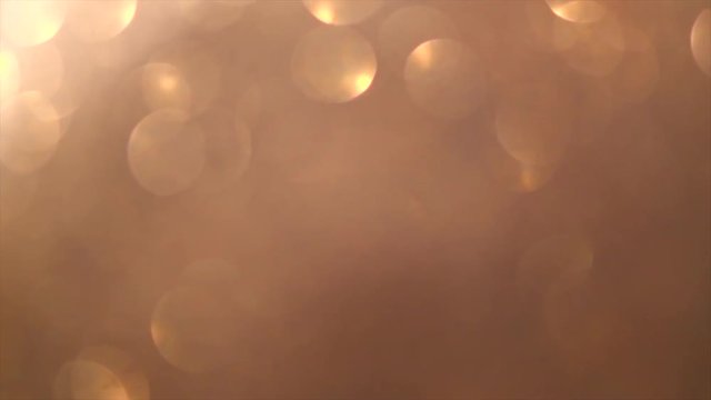 Glitter beige with golden sparkles background. Gold glittering dust backdrop. Christmas golden light shine particles bokeh. Holiday concept. 4K UHD video