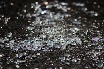 transparent shards of a windshield from the car on asphalt of parking.