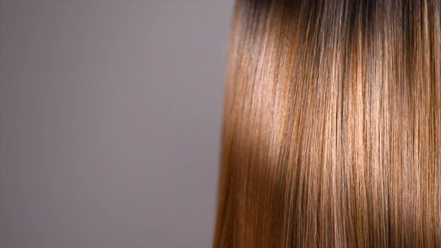 Hair. Beautiful healthy long smooth flowing brown hair closeup texture. Dyed straight hair background. Slow motion. 3840X2160 4K UHD video footage