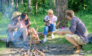 Naklejka na ściany i meble Company having hike picnic nature background. Picnic with friends in forest near bonfire. Hikers relaxing during snack time. Summer picnic. Tourists hikers sit on log relaxing waiting picnic snack