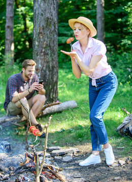 Delicious picnic food. Girl in straw hat trying roasted food nature background. Foods to cook on stick. Tips every camper should know about campfire cooking. Easy tips improve your campfire cooking